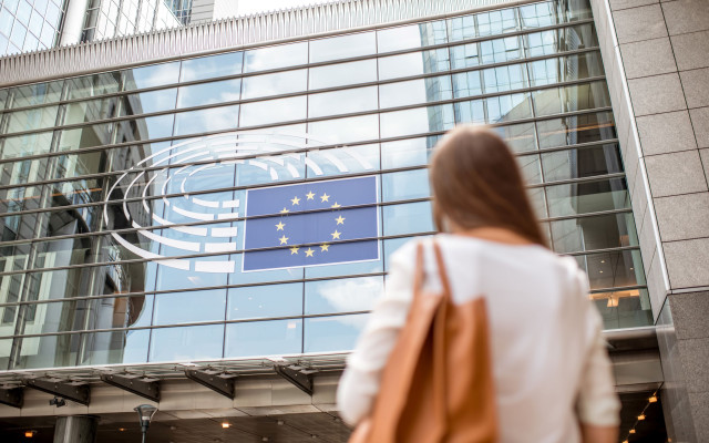 Poslovna zenska zraven zgradbe EU parlamenta v Bruslju 30.3.2025