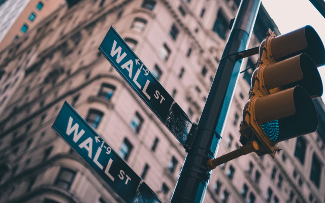 Slika stebra s prometnim semaforjem in dvema smerokazoma za Wall Street v zamegljenem ozadju poslovna stavba 20.11.2023