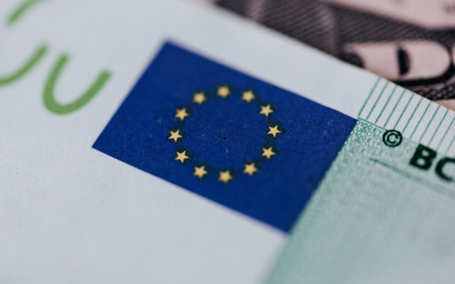 Slika znaka EU 12 rumenih zvezdic na modri podlagi na stiliziranem bankovcu za 100 EUR