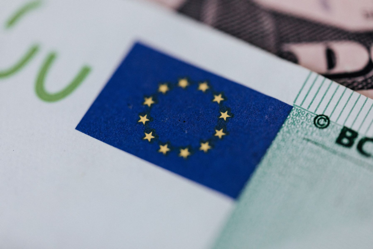Slika znaka EU 12 rumenih zvezdic na modri podlagi na stiliziranem bankovcu za 100 EUR