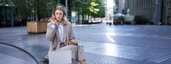 woman sitting on a street with laptop and headphon 2023 11 27 05 30 49 utc min 1